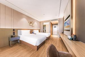 Ένα ή περισσότερα κρεβάτια σε δωμάτιο στο Orange Hotel Beijing Yizhuang Rongjing West Street