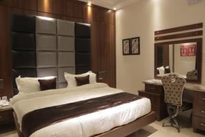 a bedroom with a bed and a desk and a mirror at Kadi Hotel in Najran