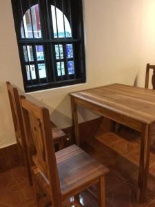 a table and chairs in a room with a window at Sysomphone G.H in Luang Prabang