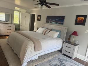 a bedroom with a large bed with a ceiling fan at Pamoyo Place in Albany +28 photos