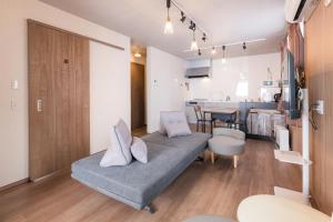 a living room with a couch and a kitchen at Lumen豊田 ガス乾燥機と駐車場無料の中長期滞在向コンドミニアム in Toyota
