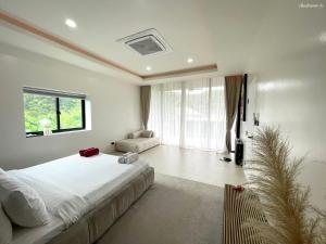 ラワイビーチにあるVilla Astra Rawai Phuketの大きなベッドと大きな窓のある寝室 +141枚の写真
