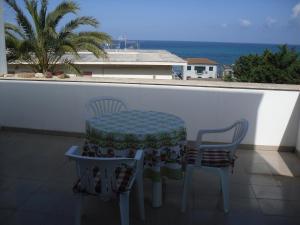 a table and two chairs on a balcony with the ocean at Delle Zagare Apartments in Alcamo Marina