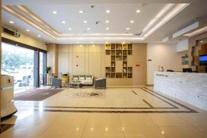 a large room with a lobby with a table and chairs at GreenTree Inn Shanghai National Convention and Exhibition Center Huaxiang Road in Shanghai