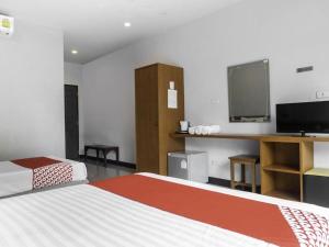 a hotel room with two beds and a flat screen tv at OYO 567 U Residence in Ban Lamai +141 photos