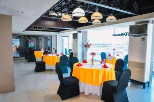 a dining room with yellow and blue tables and chairs at Marcian Business Hotel in Zamboanga