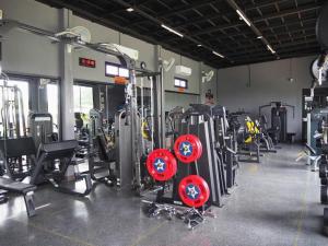 a gym with a bunch of treadmills and machines at The Hub Hotel Surin in Surin