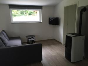 a living room with a couch and a window at Le Clos du Silberthal in Steinbach
