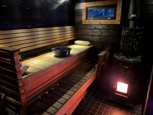 a wooden bench in a room with a bucket on it at Log cabin by the lake in Pieksamaki