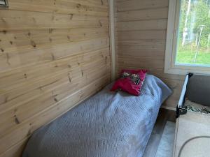 a small room with a bed in a wooden wall at Log cabin by the lake in Pieksamaki +5 photos