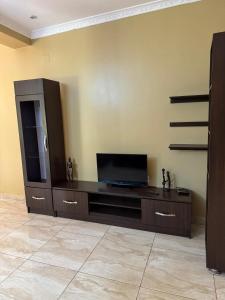 a living room with a entertainment center with a flat screen tv at Dafrican BnB villa in Kigali
