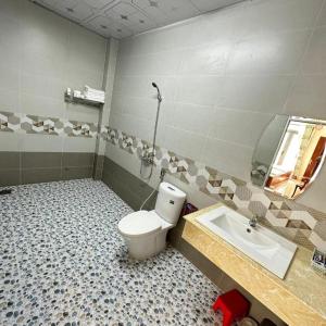 un baño con inodoro y lavabo en Phi Mai Hotel, en Ấp Vĩnh Tây (2)