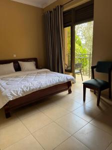 a bedroom with a bed and a chair and a balcony at Dafrican BnB villa in Kigali