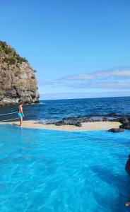 Una donna in piedi su una spiaggia vicino all'oceano di Lagoa Princess Condo a Lagoa