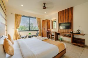 Un dormitorio con una cama, un escritorio y un televisor. en Hotel Woodlark, en Kattappana