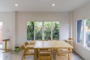 乌隆他尼Maximize Brand New Hostel Udonthani的配有木桌椅的餐厅