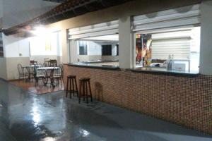 a restaurant with a bar with chairs and tables at Barrocos Hotel in Rondonópolis