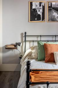 1 dormitorio con 1 cama con almohadas de color verde y naranja en L'Alloggio di San Pellegrino, en Viterbo