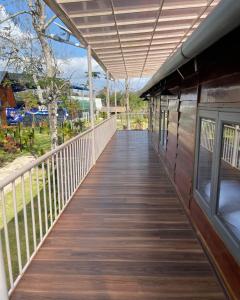 a wooden walkway leading to a building with a window at The Lake Farm - Dak Lak in Buon Ma Thuot +37 photos
