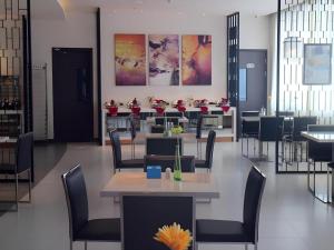 een eetkamer met tafels, stoelen en bloemen bij Jinjiang Inn Pingliang West Railway Station Xuanhe New City in Pingliang