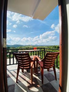 a patio with two chairs and a table on a balcony at Coorg Mountain View in Madikeri