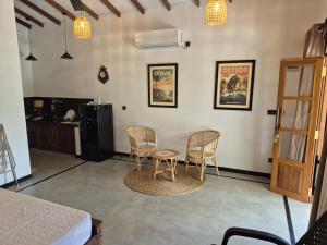 a room with a table and chairs and a kitchen at the cinnamon home in Koggala