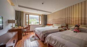 a hotel room with two beds and a teddy bear on the floor at Dongya Hotel in Jiuhuajie +153 photos