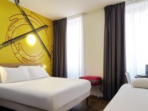 a hotel room with two beds and a yellow wall at ibis Styles Marseille Gare Saint-Charles in Marseille