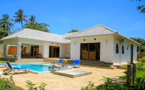a house with a swimming pool and blue chairs at Villa marina in Mombasa