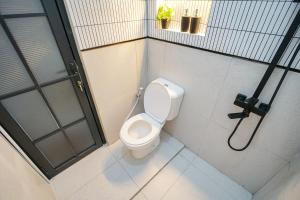 ein Badezimmer mit Toilette und Dusche in der Unterkunft Oemah Rotan Homestay Jogja in Yogyakarta + 21 Fotos