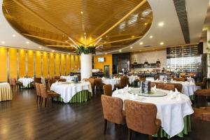 a dining room with white tables and chairs at Shenzhen Dameishawan Youtinghui Hotel in Shenzhen