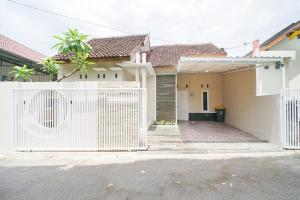 ein weißer Zaun vor einem Haus in der Unterkunft Oemah Rotan Homestay Jogja in Yogyakarta