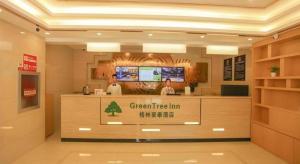 een lobby van een groene herberg met twee personen bij GreenTree Inn Beijing Xicheng District Daguanying Subway Station Shell in Beijing