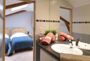 une salle de bain avec lavabo et une chambre dans l'établissement Auberge du Couvige, à Le Bouchet-Saint-Nicolas
