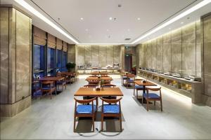 a dining room with wooden tables and chairs at Yitel Collection Shenyang North Railway Station Metro Station in Shenyang
