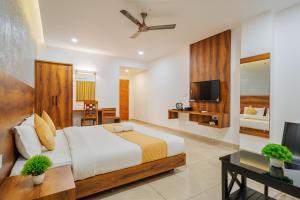 Un dormitorio con una cama grande y un televisor. en Hotel Woodlark, en Kattappana