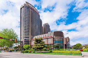 a tall building on a city street with a traffic light at Junyu Grand Hotel Qinhuangdao in Qinhuangdao