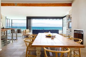a dining room with a table and a view of the ocean at Villa Misty Cliffs in Scarborough