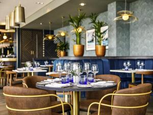 a dining room with tables and chairs with wine glasses at Mercure Paignton Hotel in Paignton