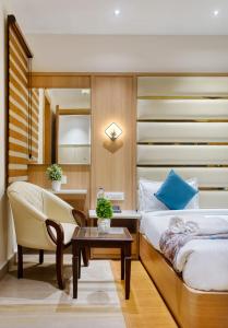 a bedroom with a bed and a chair and a table at Hotel Holiday Dreamz in Amritsar