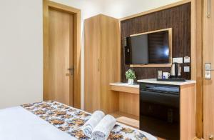 a hotel room with a bed and a flat screen tv at Hotel Holiday Dreamz in Amritsar