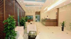 a lobby with white furniture and plants in a building at Shijia Inn On the Bund in Shanghai