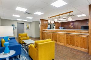 a waiting room with yellow chairs and a bar at Comfort Inn Huntington near University area in Huntington