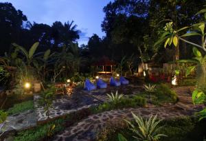 Ein Garten bei Nacht mit blauen Stühlen und Lichtern in der Unterkunft 1 Bedroom Pool Villa Bebandem Karangasem in Bebandem