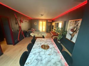 a room with a table and chairs in a room with red lighting at Love&spa in Valras-Plage