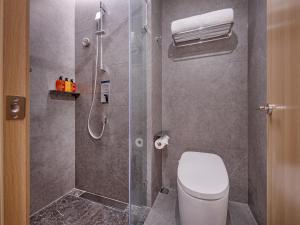 a bathroom with a shower with a toilet and a glass door at Orange Hotel Beijing South Railway Station South Square in Beijing +27 photos