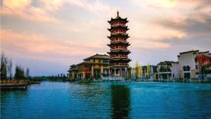 a large tower sitting in the middle of a lake at GreenTree Inn Puyang Pushang Huanghe Road in Zhongyuanyoutian