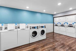 a laundry room with white washers and dryers at WoodSpring Suites St Peters-OFallon in Saint Peters