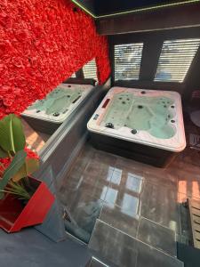 two jacuzzi tubs in a room with red walls at Love&spa in Valras-Plage
