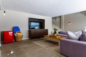 a living room with a purple couch and a table at Villa Misty Cliffs in Scarborough